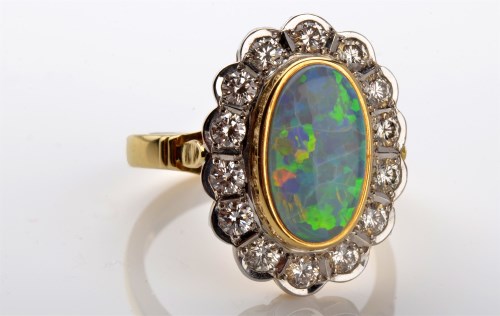 Lot 1096 - An opal and diamond cluster ring, the oval...