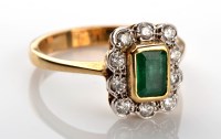 Lot 1098 - An emerald and diamond cluster ring, the step...