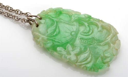 Lot 1115 - A jadeite plaque, carved to depict a fruiting...
