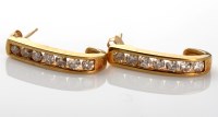 Lot 1117 - A pair of diamond earrings, of half-hoop...