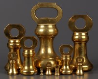 Lot 1226 - A set of ten brass bell-shaped weights,...