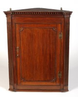 Lot 1392 - † A Georgian oak hanging corner cupboard with...