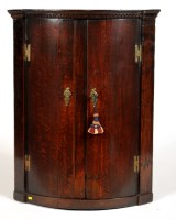 Lot 1483 - A George III oak hanging corner cupboard, with...