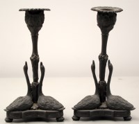 Lot 1750 - A pair of patinated bronze candlesticks, the...