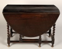 Lot 1823 - An ebonised oak drop leaf gate-leg table with...