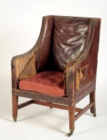 Lot 1873 - A wing easy chair covered in leather, raised...