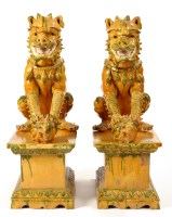 Lot 492 - A pair of Sancai glazed lion dogs, each seated...