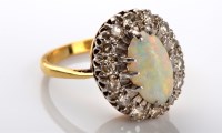 Lot 812 - An opal and diamond dress ring, the oval...