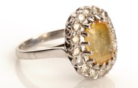 Lot 827 - A yellow sapphire and diamond cluster ring,...