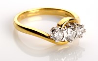 Lot 865 - A three stone diamond ring, the graduated...