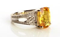 Lot 873 - A yellow sapphire and diamond ring, the...