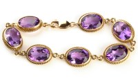 Lot 879 - An amethyst bracelet, each of the seven links...