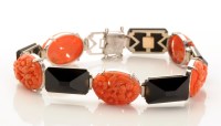 Lot 748 - A carved coral and onyx bracelet, the coral...