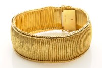 Lot 754 - An 18ct. yellow gold bracelet, of textured...