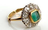 Lot 819 - An emerald and diamond cluster ring, the...