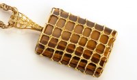 Lot 857 - A tiger's eye and 9ct. yellow gold pendant,...