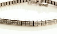 Lot 910 - A diamond line bracelet, each of the...