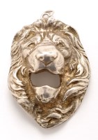 Lot 669 - A white metal lion mask pendant, 2 3/8in. (6cms).