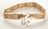 Lot 762 - A 9ct. yellow gold gate link pattern bracelet,...