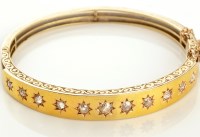 Lot 809 - A diamond and yellow metal bangle, the front...