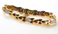 Lot 835 - An 18ct. gold and diamond bracelet, set with...