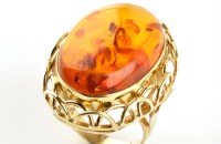 Lot 843 - An amber and yellow metal ring, the central...