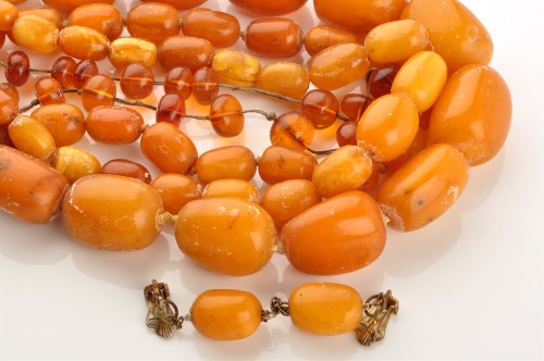 Lot 861 - Four amber necklaces, the largest of oval...