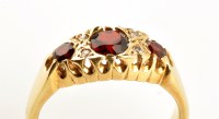 Lot 883 - A garnet and diamond ring, the three tapered...