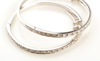 Lot 890 - A pair of diamond and 9ct. white gold hoop...