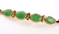 Lot 929 - A yellow metal and jadeite panelled bracelet,...