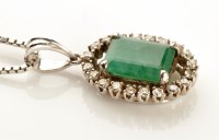 Lot 944 - An emerald and diamond cluster pendant, the...