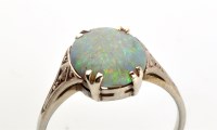 Lot 945 - A black opal ring, the oval black opal set...