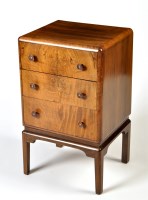 Lot 137 - A walnut bedside chest of three drawers,...