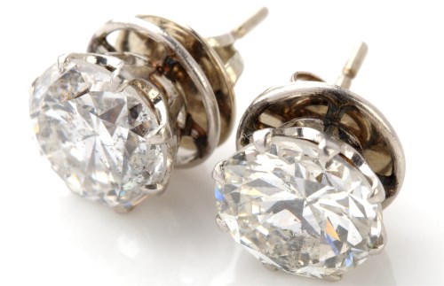 Lot 668 - A pair of diamond stud earrings, each set with...