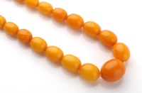 Lot 729 - An amber single row graduated bead necklace,...