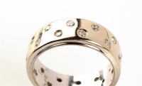 Lot 799 - A modern design diamond and gold eternity ring,...