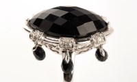 Lot 803 - An onyx, diamond and white metal ring, the...