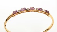 Lot 813 - An amethyst and diamond bangle, each of the...