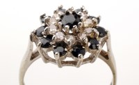 Lot 820 - A diamond and sapphire cluster ring, the...