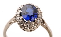 Lot 821 - A sapphire and diamond cluster ring, the oval...