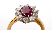 Lot 834 - A ruby and diamond cluster ring, with central...