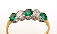 Lot 852 - A five stone emerald and diamond ring, the...