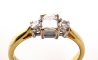 Lot 869 - A three stone diamond ring, the central...