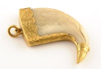 Lot 886 - A yellow metal mounted tiger claw pendant,...