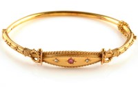 Lot 892 - A 9ct. gold pink stone and diamond set bangle,...