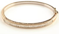 Lot 893 - A diamond set bangle, channel set with...