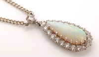 Lot 895 - An opal and diamond cluster pendant, the pear...