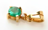 Lot 904 - An emerald and diamond pendant, the oval facet...