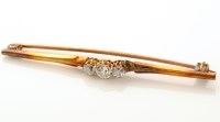 Lot 912 - A three stone diamond bar brooch, the old...