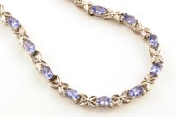 Lot 944 - A tanzanite set silver necklace, each of the...